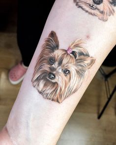 a small dog tattoo on the right arm and leg, with two dogs behind it