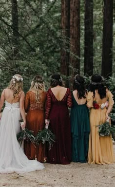 a group of women standing next to each other in the woods