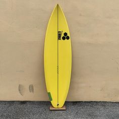 a yellow surfboard leaning up against a wall