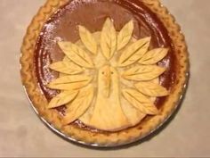 a pie with leaves on it sitting on top of a table