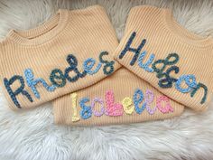 two knitted sweaters with the words free hugs and peace written on them in multicolored letters