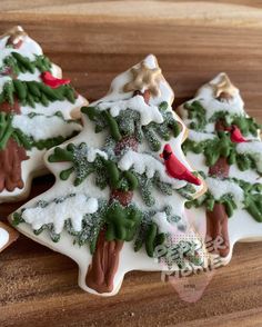 three decorated cookies sitting on top of a wooden table