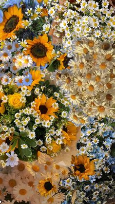 a bunch of sunflowers and daisies in vases