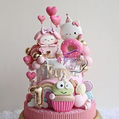 a pink cake with hello kitty decorations on top