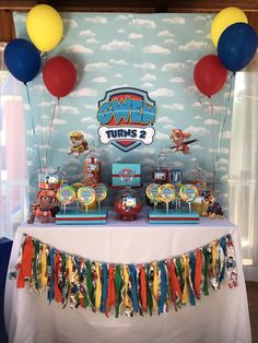 a table topped with lots of candy and balloons