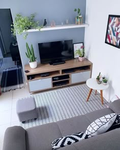 a living room filled with furniture and a flat screen tv on top of a wooden entertainment center