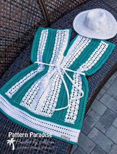 a green and white crocheted dress with a hat on it