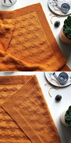 an orange knitted blanket sitting on top of a table next to a potted plant