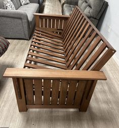 a living room filled with furniture and lots of wooden flooring next to a couch