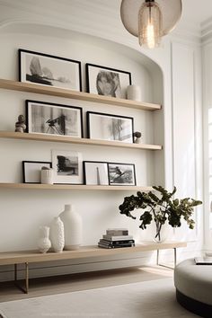 a living room filled with furniture and framed pictures on the wall above it's shelves