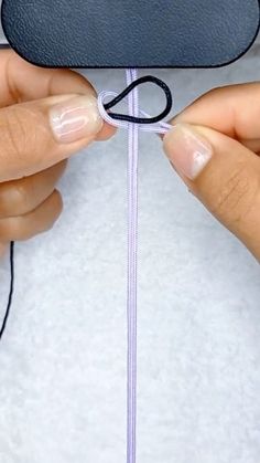 two hands are stitching together a piece of fabric to make a cloud ornament