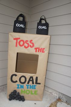 a cardboard box that says toss the coal in the hole and two bags on top