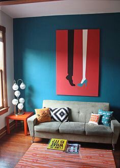 a living room filled with furniture and a large painting on the wall above it's couch