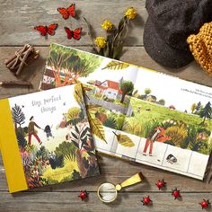 two children's books on a wooden table with flowers and other things to read