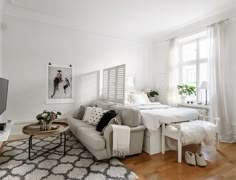 a living room filled with furniture and a flat screen tv on top of a hard wood floor