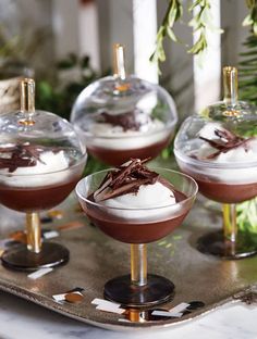 three desserts in glass dishes on a tray