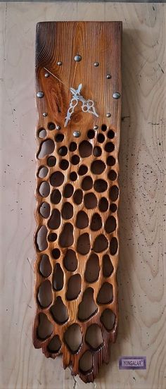 a piece of art made out of wood with circles and holes on the bottom half