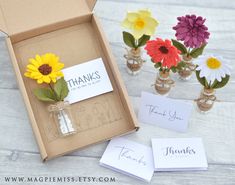 small vases filled with flowers sitting next to each other