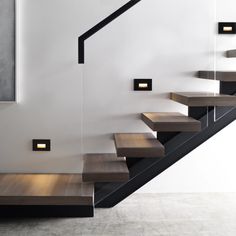 a set of stairs leading up to the second floor in a modern house with white walls and black railings