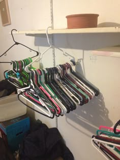 the closet is filled with many different types of shirts and pants hanging from hooks on shelves