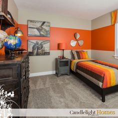 a bedroom with an orange and gray color scheme on the wall, carpeted floor