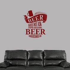 a living room with a couch and a wall decal that says beer does not ask