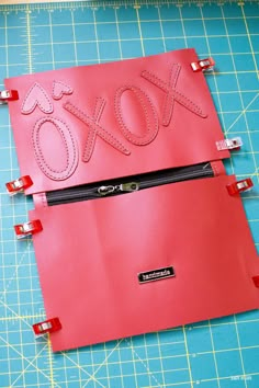 a piece of red paper with the word xoxo cut out on it next to a pair of scissors