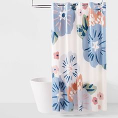 a shower curtain with blue and pink flowers on it next to a white toilet bowl