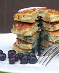 blueberry pancakes stacked on top of each other with a bite taken out of one