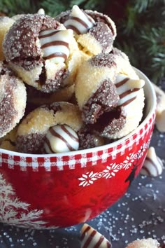 a bowl filled with chocolate covered donuts on top of a table next to candy canes