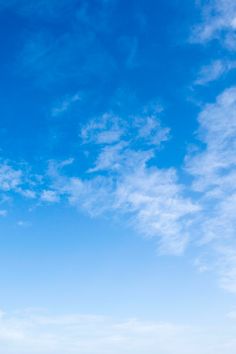 two people are standing on the beach with their surfboards in hand and one person is flying a kite