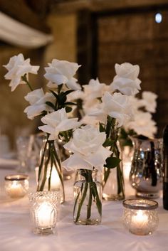 Wedding white roses White Rose Candle Centerpiece Wedding, Simple White Rose Table Decor, Little Vases With Flowers Wedding, White Roses In Bud Vases Wedding, Non Candle Centerpieces Wedding, Roses In Bud Vases Wedding, White Roses Candles Wedding, White Roses At Wedding, White Rose Candle Centerpiece