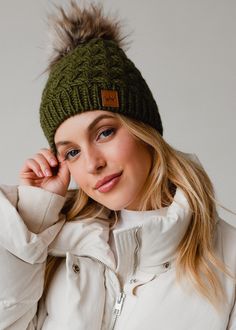 You can never have too many winter hats, and this pom hat is no exception. Our  new olive knit fleece lined pom hat from our latest collection is one you won't want to miss out on!  Olive green knit hat Natural faux fur pom accent Crown patch on the left side One size Designed in the U.S.A. Produced in China.  100% Acrylic Matching mittens available Knitted Hats Kids, Pom Pom Beanie Hat, Knit Jewelry, Crochet Clothing, Olive Green Color, Knit Beanie Hat, Long Jumpsuits, Pom Pom Hat, Hats For Sale