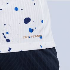 the back of a man's shirt with blue paint splattered on it