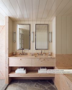 a bathroom with two sinks and mirrors on the wall