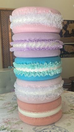 a stack of different colored pillows sitting on top of a table