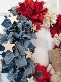 a patriotic wreath with red, white and blue stars on it's front door