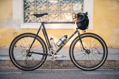 a bicycle parked on the side of a road next to a building with a window