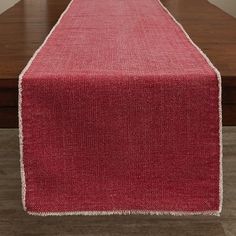 a red table runner on top of a wooden table