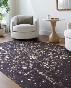 a living room with two chairs and a rug