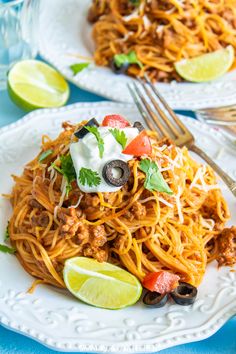 two plates of spaghetti with meat and vegetables