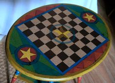 a small wooden table with a checkerboard design on the top and star accents