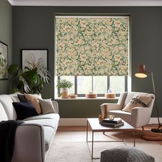 a living room filled with furniture and a window covered in roman shades on the windowsill