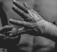 two hands with bandages on them are holding each other's fingers in black and white