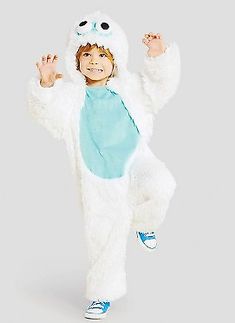 a little boy in a white costume standing on one leg and wearing a blue shirt