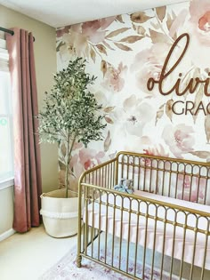 a baby's room decorated in pink and gold with flowers on the wall, crib next to a potted tree