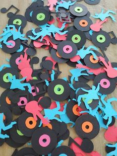 an assortment of paper cut out animals on a wooden table with circles and holes in the middle