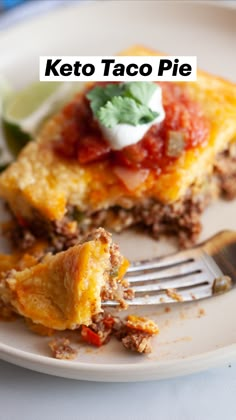 a piece of keto taco pie on a plate with a fork and lime wedge