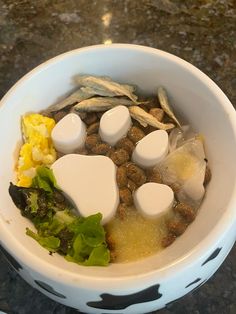 a white bowl filled with food on top of a table