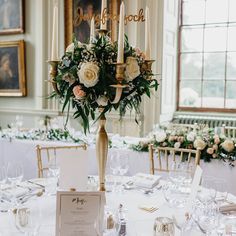 the centerpieces in this wedding reception table are adorned with roses and greenery